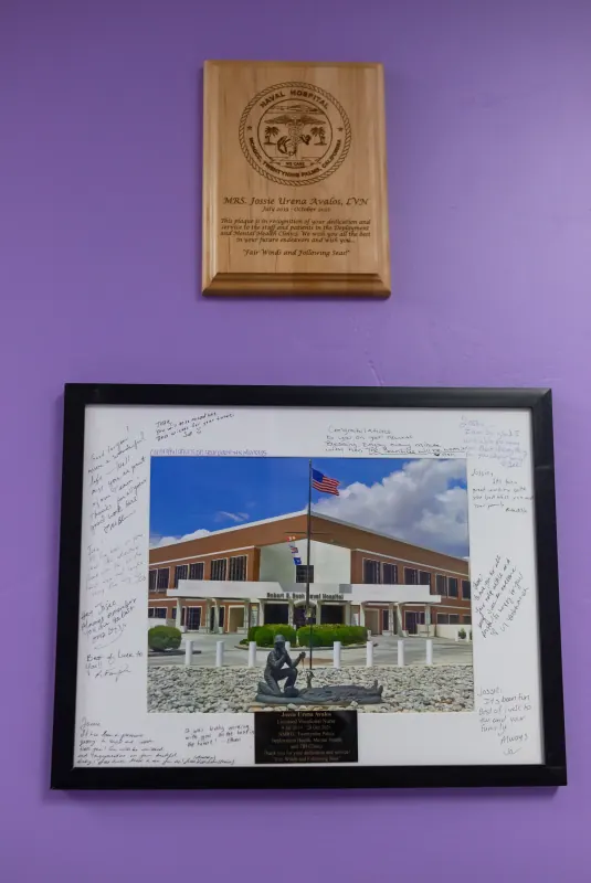 Engraved wooden plaque mounted above a framed and signed farewell photograph
