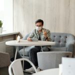 A young man speaks with an ADHD specialist on an ipad in his home.
